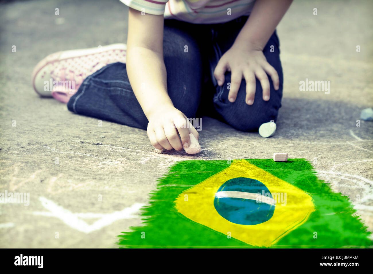 Child drawing Brazil`s flag on the ground Stock Photo
